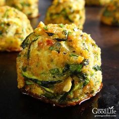 zucchini balls with spinach and cheese are on a black surface, ready to be eaten