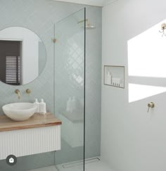 a bathroom with a sink, mirror and stand up shower stall in it's corner