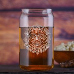 a glass jar filled with liquid next to a bowl of popcorn