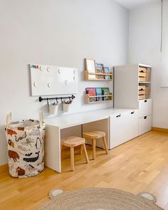 a room with white walls and wooden flooring, including a toy storage unit on the wall