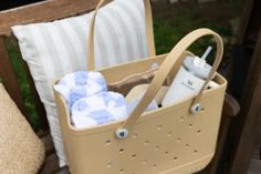 a basket filled with items sitting on top of a wooden bench next to a pillow