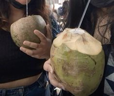 two women holding coconuts in their hands