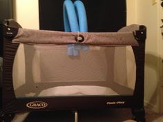 a baby crib with two blue sticks sticking out of it's back end