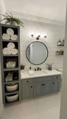 a white bathroom with gray cabinets and shelves