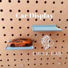 an orange toy car sitting on top of a shelf next to a lion sticker