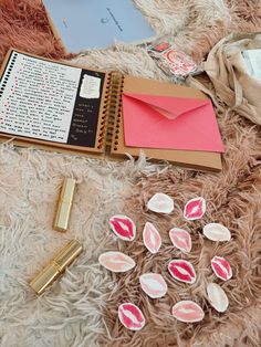 an open notebook with pink lips on it next to some papers and lipstick stickers