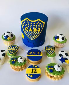 cupcakes decorated with soccer themed icing and fondant decorations are displayed in front of a cake