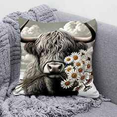 a cow with long horns and daisies on it's face sitting on a couch