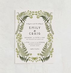 a wedding card with greenery on it