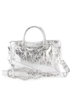 Balenciaga relaunches its iconic Y2K bag with this updated style that's crafted from crinkled metallic lambskin leather and detailed with polished hardware. Top zip closure Top carry handles; removable, adjustable shoulder strap Exterior zip pocket Interior zip pocket Cotton-canvas lining Leather Made in Italy Designer Handbags Designer Silver Textured Leather Bag, Luxury Silver Textured Leather Bag, Metallic Leather Bag With Dust Bag Included, Trendy Metallic Leather Bags, Designer Silver Textured Leather Shoulder Bag, Designer Silver Satchel With Double Handle, Luxury Silver Satchel With Palladium Hardware, Silver Leather Satchel With Top Carry Handle, Silver Leather Trendy Satchel