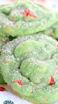 green cookies with red sprinkles are on a table