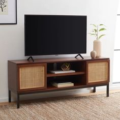 a flat screen tv sitting on top of a wooden entertainment center