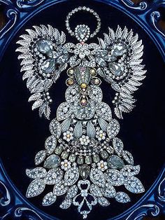 an intricately designed brooch is shown in a blue frame