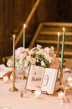 the table is set with candles, flowers and an open book that says foflet