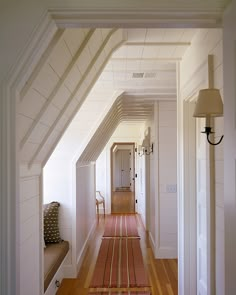 a hallway with white walls and wooden floors