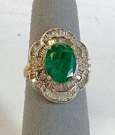 14K Yellow Gold Emerald & Diamond Cocktail Ring Description14K Yellow Gold Cocktail Ring; 1 Oval Emerald 3.52 Carat; 10 Round Brilliant Cut Diamonds Approximately 0.20 Carat Total Weight, SI-3, L-M; 64 Baguette Cut Diamonds 1.68 Carat Total Weight, SI-3, L-M; Finger Size 6; 7.5 Grams. Payment All payments must be made through PayPal, NO EXCEPTIONS. We cannot accept payment plans. We do not offer Layaway. Shipping We ship via USPS Registered Mail, Return Receipt in order to provide tracking and insured delivery, which usually takes 5-7 days ($25) **OVERNIGHT SHIPPING available upon request ($40); please request overnight shipping upon your winning bid!! Expedited shipping fee will be added to your total AND expedited shipping service will be arranged for you.  We ship within one business da Gia Certified Oval Collectible Ring, Oval Emerald Ring Fine Jewelry Collectible, Green Oval Diamond Ring Collectible, Formal Green Cluster Ring Stamped 14k, Green 14k Stamped Cluster Ring For Formal Occasions, Formal Green 14k Stamped Cluster Ring, Estate Oval Diamond Ring With Hallmark, Estate Style Oval Hallmarked Diamond Ring, Estate Oval Hallmarked Diamond Ring