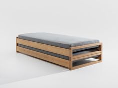 a wooden bench with two drawers on the bottom and one drawer open to reveal a bed