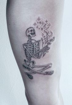 a skeleton sitting on the ground with flowers in it's hand and holding a flower