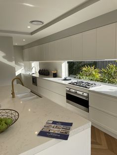 a modern kitchen with white cabinets and marble counter tops