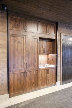 an empty kitchen with wood paneling on the walls