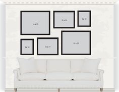 a white couch sitting in front of a wall with four black framed pictures on it