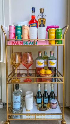 a gold bar cart filled with bottles and glasses