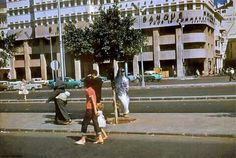 people crossing the street in front of buildings