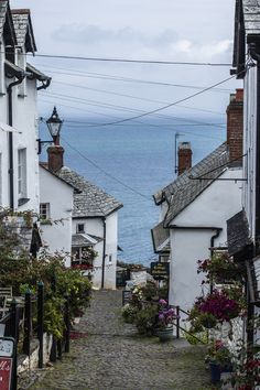 an old cobblestone street leads to the ocean in this small town by the sea