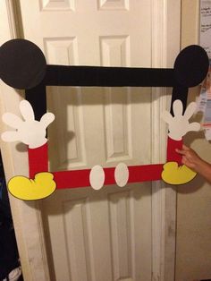 someone is holding up a mickey mouse door decoration