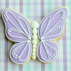 a cookie decorated like a butterfly on a checkered tablecloth