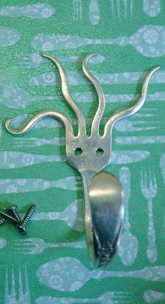 a metal spoon and fork on a green table