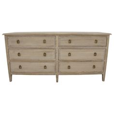 a white dresser with several drawers and handles on it's sides, against a white background