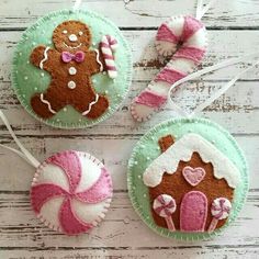 three ornaments made to look like gingerbreads and candy canes on a white wooden table