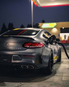 a car is parked at a gas station with its fuel nozzles on it