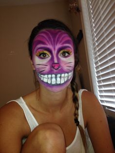 a girl with her face painted like a cat