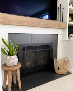 a fireplace with a potted plant on top of it and a basket next to it