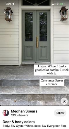 the front door of a white house with two green double doors and an advertise for