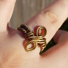 Go for the brass ring! With its subtle infinity symbol and woven band, this unique brass ring is understated but bold. The elegantly curved design would be equally at home at a summer wine festival and a steampunk convention. Handmade and one of a kind, this ring would make a beautiful birthday gift for a teenager, a Valentine's Day gift for your loved one, or a treat for yourself! The minimalist style makes it the perfect subtle accompaniment for any outfit at any occasion. Like what you see, but want a different size or metal choice? Not a problem! Contact me for custom-made jewelry along the same lines. I'm more than happy to work up something more suited to your own personal color palette, or produce another version specifically tailored to the outfit you had in mind. Ships from Boston Adjustable Bronze Metal Midi Rings, Handmade Minimalist Brass Stackable Rings, Minimalist Adjustable Copper Ring, Handmade Minimalist Brass Midi Rings, Handmade Adjustable Infinity Ring, Handmade Minimalist Infinity Rings, Minimalist Handmade Infinity Rings, Wire Rings Tutorial, Infinity Rings