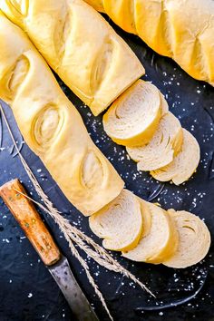 slices of bread sitting on top of a cutting board next to a knife and butter