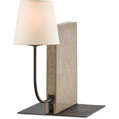 a lamp that is sitting on top of a stone block with a white shade over it