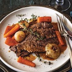 a white plate topped with meat, potatoes and carrots