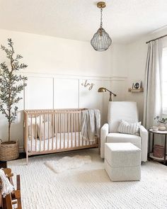 a baby's room with a crib, chair and ottoman