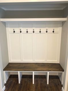 a white bench sitting in the corner of a room