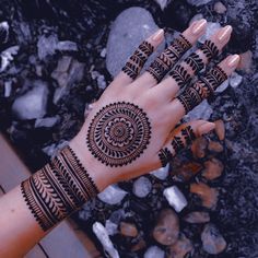 a woman's hand with hennap on it and rocks in the background