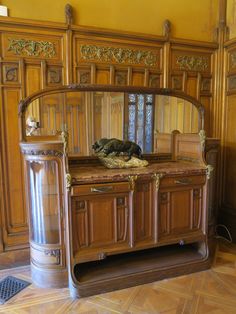 an old wooden cabinet with a cat sleeping on top