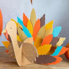 a paper turkey sitting on top of a wooden table