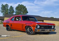 an orange muscle car parked in a parking lot