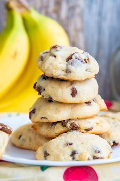 a stack of cookies sitting on top of a white plate next to two ripe bananas