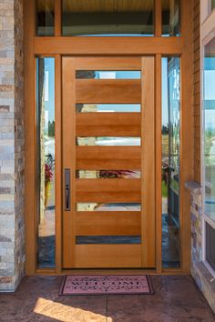 a wooden front door with glass panels