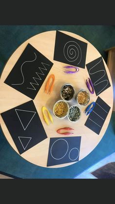 a wooden table topped with bowls and cups filled with different types of items on top of it